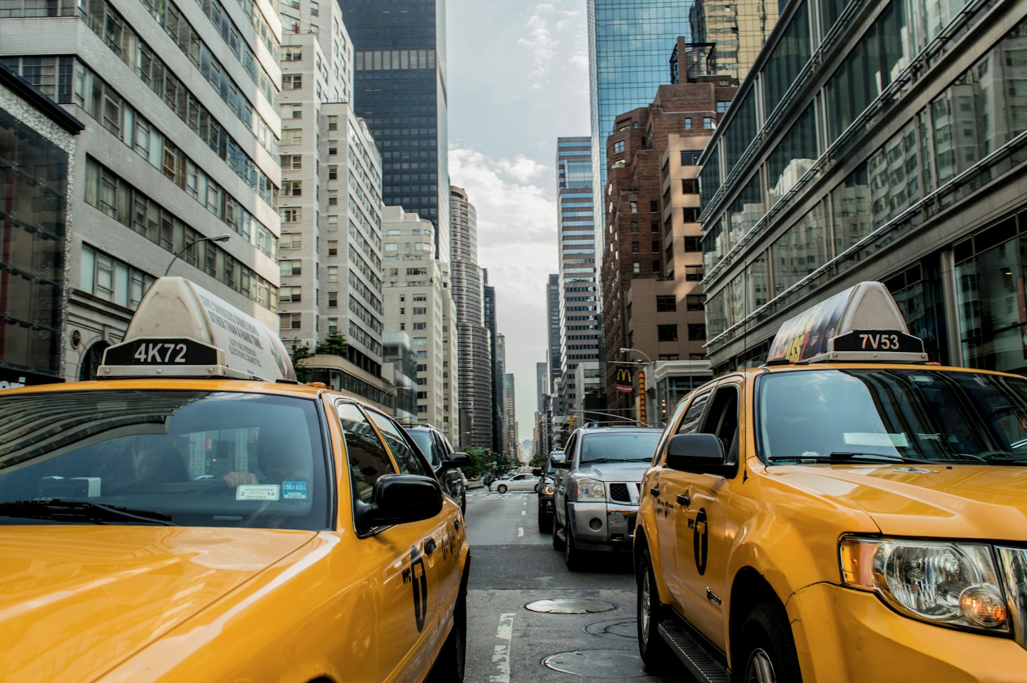 Busy city street with yellow taxis and tall buildings.
